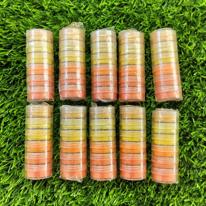 Stacks of small cylindrical containers with gradient colors on a grass (Mica powder) background